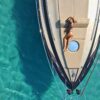 woman in black bikini lying on blue and white boat during daytime